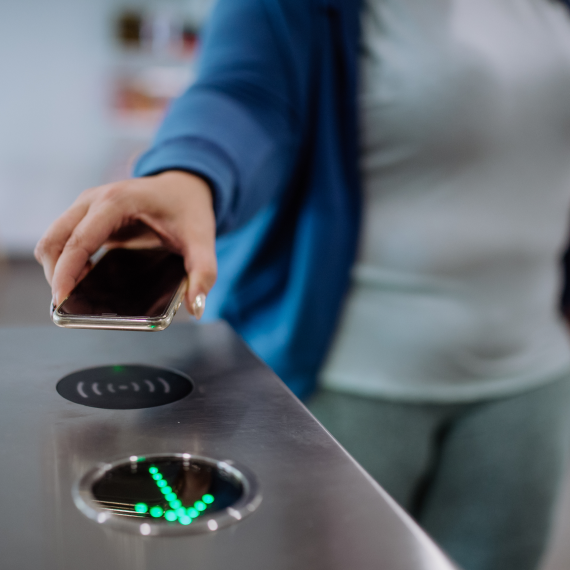 Woman scanning smartphone at an NFC gate