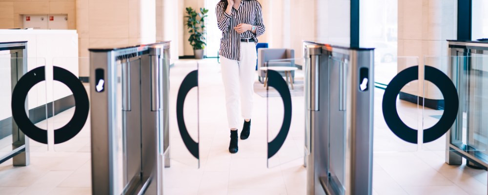 Woman walking towards access control swing barrier
